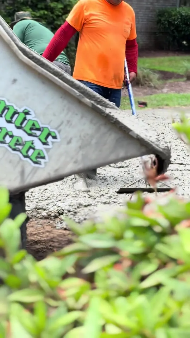 Premier Concrete crew in hi-vis shirts working a pour with the branded power buggy and van