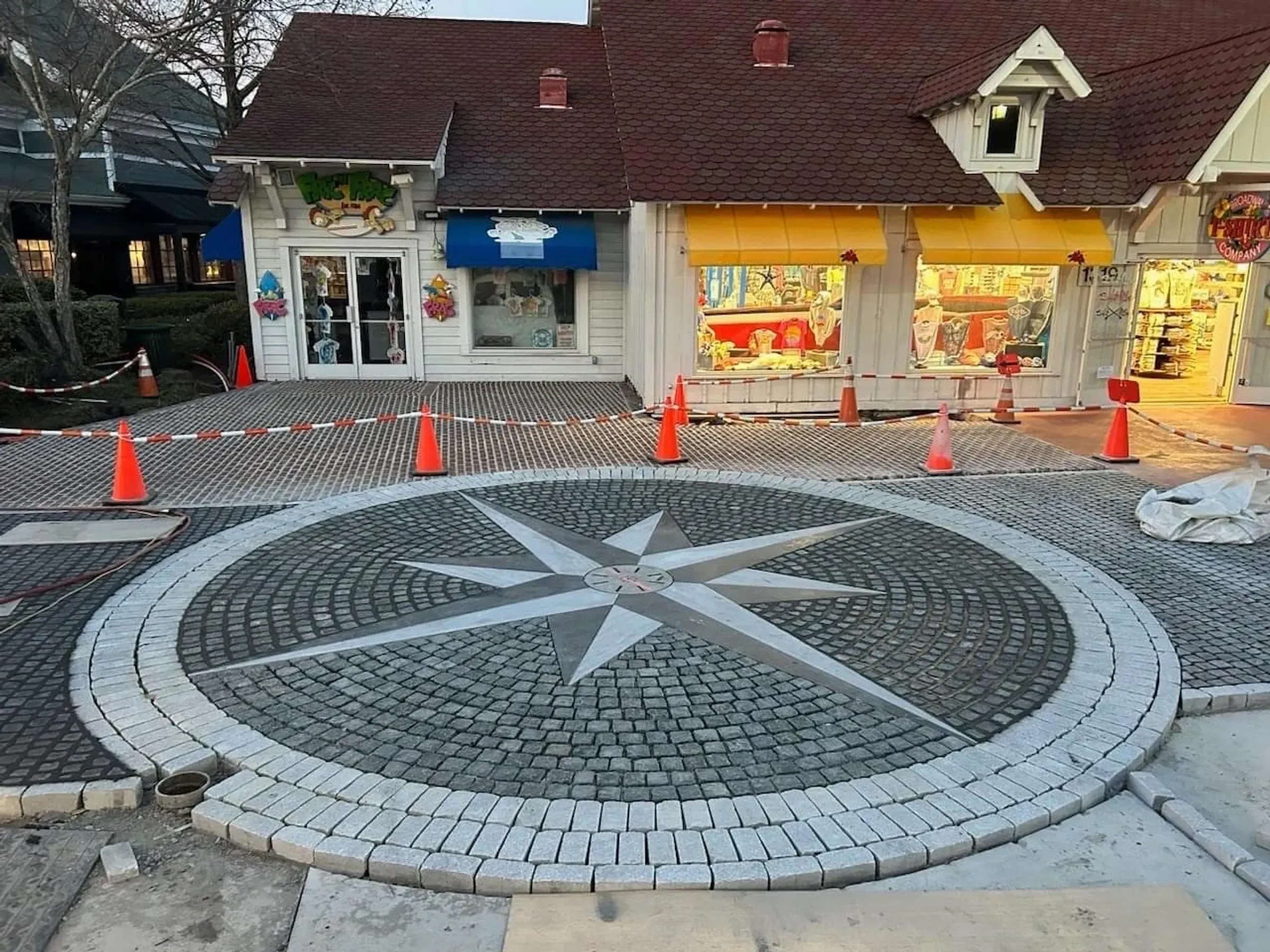 Bluestone paver patio with a brick seat-wall and fall mums in planters
