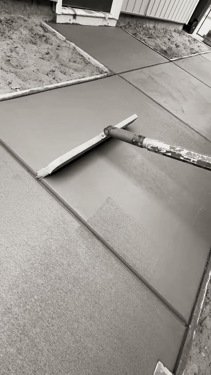 Premier Concrete crew running a bull-float finishing pass across a freshly poured slab